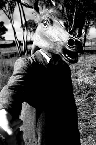 Man in a horse mask shaking hands